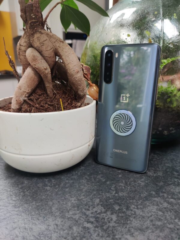 OnePlus phone on a table with a plant.